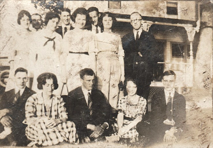 The men not standing look very unhappy to've joined this reunion.