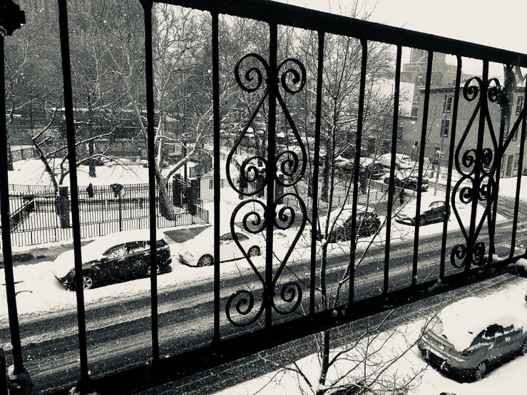looking out on a snowy street through a fire escape (photo)