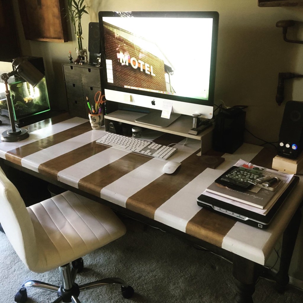 photo of refinished, white and gold striped desk with computer and other desk items back in place.